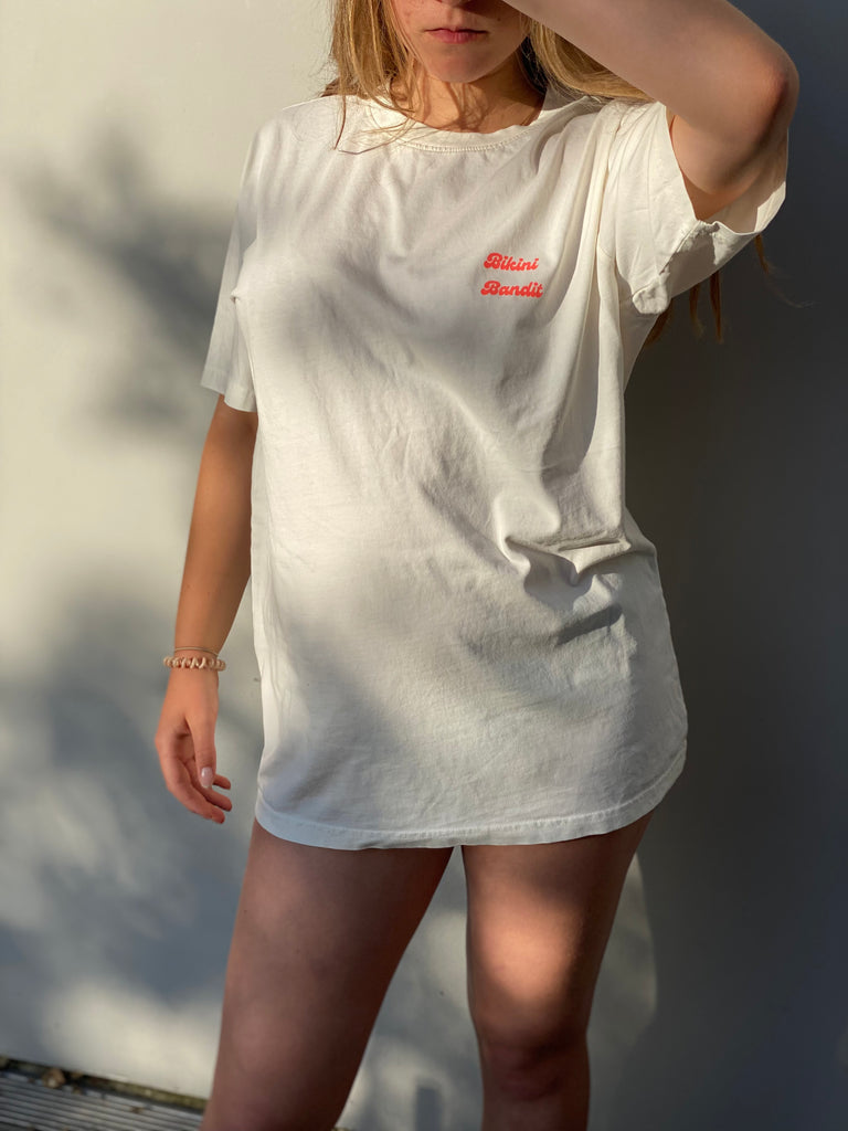 Oversized Bikini Bandit slogan T-shirt in stone wash white with neon coral  font.